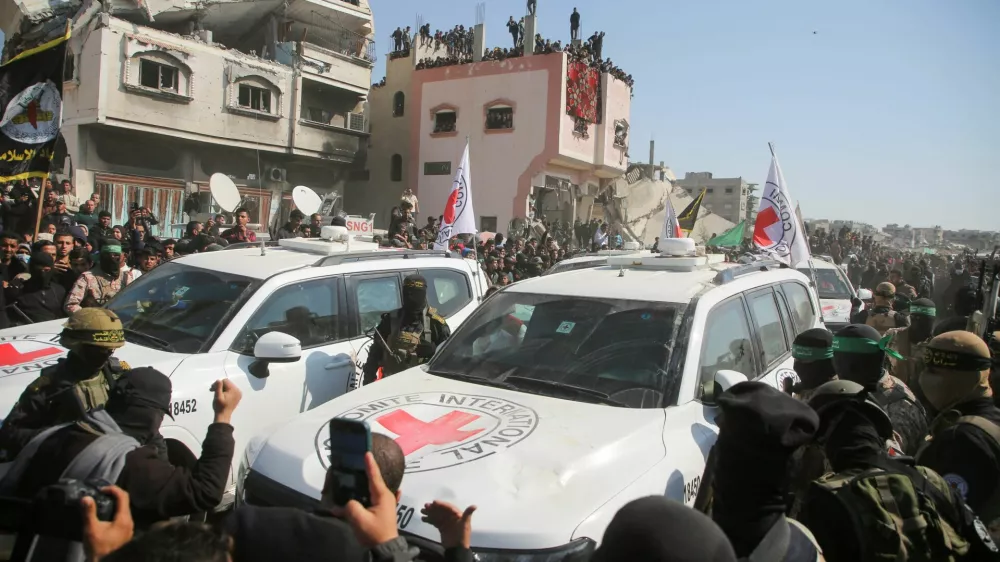 People surround the vehicles of International Committee of the Red Cross (ICRC), on the day of the release of hostages held in Gaza since the deadly October 7 2023 attack, as part of a ceasefire deal in Gaza between Hamas and Israel, in Khan Younis in the southern Gaza Strip, January 30, 2025. REUTERS/Hatem Khaled