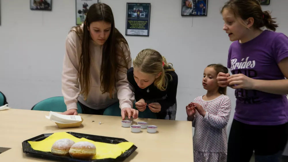 Učenke Osnovne šole Kašelj so z zanimanjem spremljale izdelovanje svečk. Foto: Bojan Velikonja