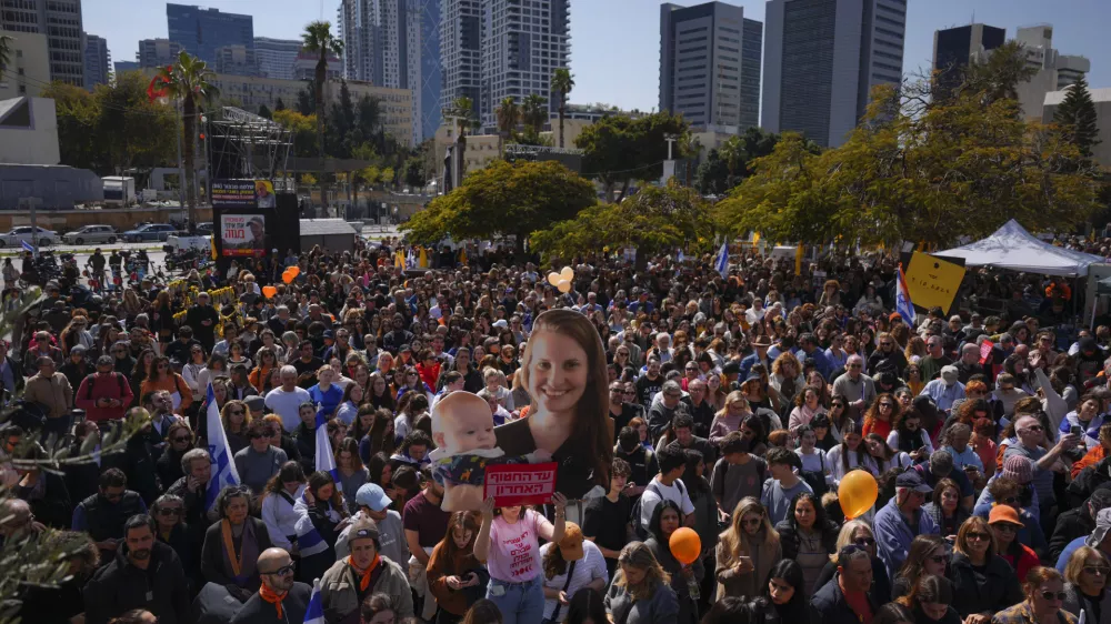 People watch a live broadcast from the funeral of slain hostages Shiri Bibas and her two children, Ariel and Kfir, at a plaza known as the Hostages Square in Tel Aviv, Israel, Wednesday, Feb. 26, 2025. The mother and her two children were abducted by Hamas on Oct. 7, 2023, and their remains were returned from Gaza to Israel last week as part of a ceasefire agreement with Hamas. (AP Photo/Ariel Schalit)