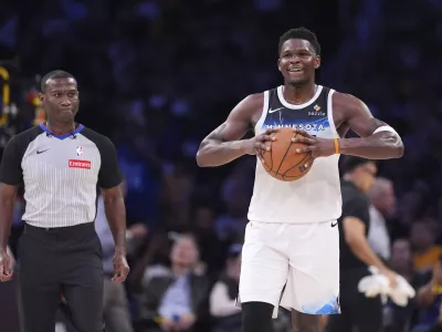 Minnesota Timberwolves guard Anthony Edwards holds the ball as a referee follows after he was ejected during the second half of an NBA basketball game against the Los Angeles Lakers, Thursday, Feb. 27, 2025, in Los Angeles. (AP Photo/Mark J. Terrill)