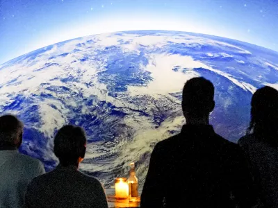 People watch the preview of the new digital exhibition "Destination Cosmos" at the former gas plant Phoenix in Dortmund, Germany, Thursday, Sept. 28, 2023. The multimedia presentation of Phoenix des Lumieres art center shows the history of man's desire to explore space from the earliest stargazers to the International Space Station and the exploration of Mars. (AP Photo/Martin Meissner)