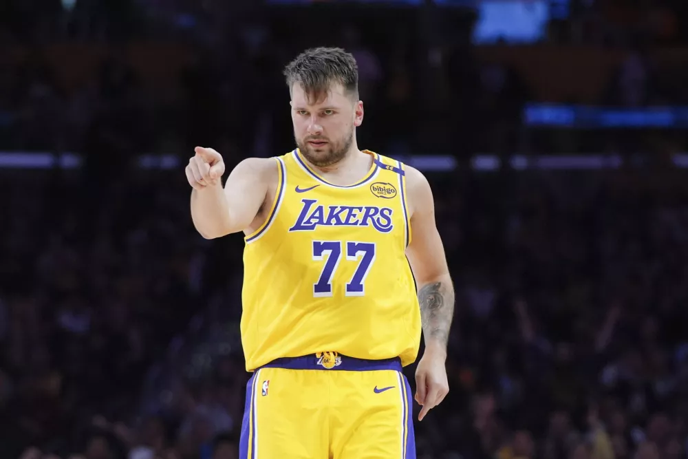 Los Angeles Lakers' Luka Doncic (77) points to his teammate after making a basket during the second half of an NBA basketball game against the New Orleans Pelicans Tuesday, March 4, 2025, in Los Angeles. (AP Photo/Jae C. Hong)