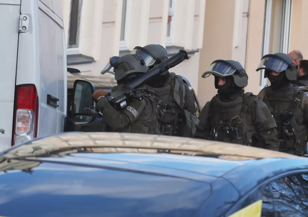 17 March 2025, Thuringia, Gera: Police officers from a special task force (SEK) are deployed in the old town. The suspect who poured a flammable liquid over a woman in a streetcar and set her on fire on March 16, 2025 is said to live there. Photo: Bodo Schackow/dpa