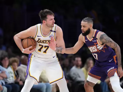 Mar 16, 2025; Los Angeles, California, USA; Los Angeles Lakers guard Luka Doncic (77) is defended by Phoenix Suns forward Cody Martin (17) in the second half at Crypto.com Arena. Mandatory Credit: Kirby Lee-Imagn Images