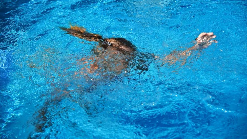 2B2CN23 Little girl drowning in water while swimming in the pool or sea.