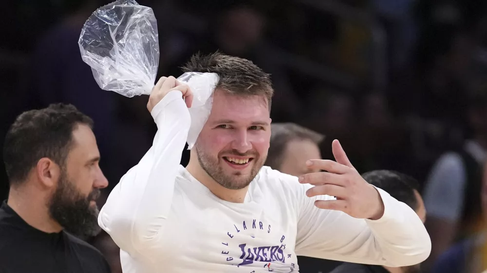 Los Angeles Lakers guard Luka Doncic holds an ice bag on his head as he comes out for the second half of an NBA basketball game against the Denver Nuggets Wednesday, March 19, 2025, in Los Angeles. (AP Photo/Mark J. Terrill)