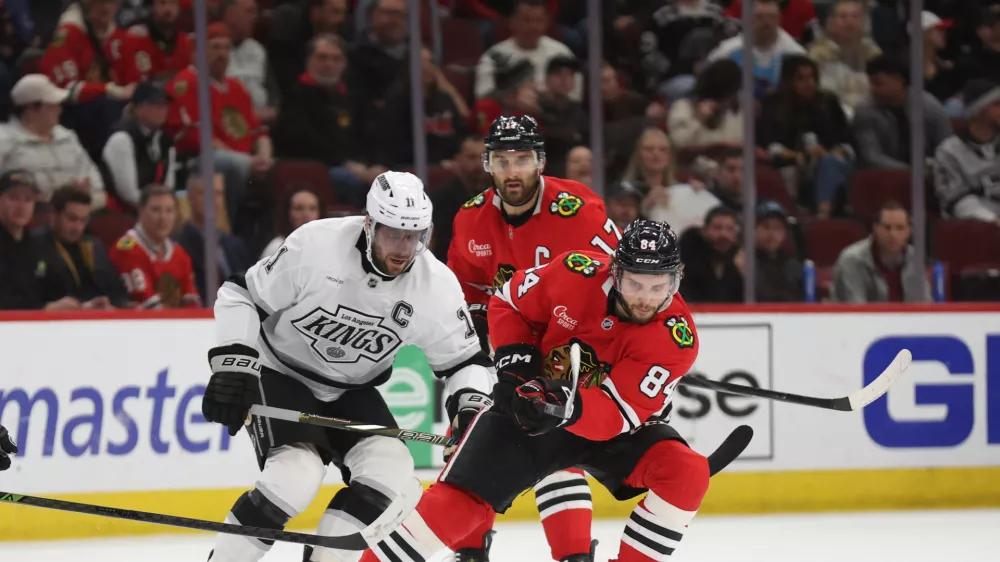 Mar 20, 2025; Chicago, Illinois, USA; Chicago Blackhawks left wing Landon Slaggert (84) and Los Angeles Kings center Anze Kopitar (11) battle for control of the puck during the second period at United Center. Mandatory Credit: Talia Sprague-Imagn Images