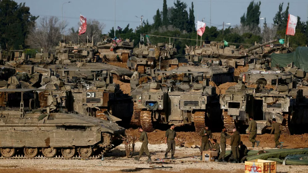 FILE PHOTO: Israeli soldiers work by military vehicles, amid a ceasefire between Israel and Hamas, near the border with Gaza, in Israel, February 15, 2025. REUTERS/Amir Cohen/File Photo