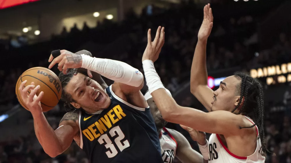 Denver Nuggets forward Aaron Gordon (32) is fouled while going to the basket during the first half of an NBA basketball game against the Portland Trail Blazers, Friday, March 21, 2025, in Portland, Ore. (AP Photo/Jenny Kane)