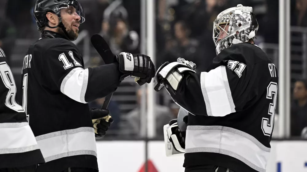 Los Angeles Kings center Anze Kopitar (11) celebrates with goaltender David Rittich (31) after they defeated the Carolina Hurricanes in an NHL hockey game in Los Angeles, Saturday, March 22, 2025. (AP Photo/Alex Gallardo)