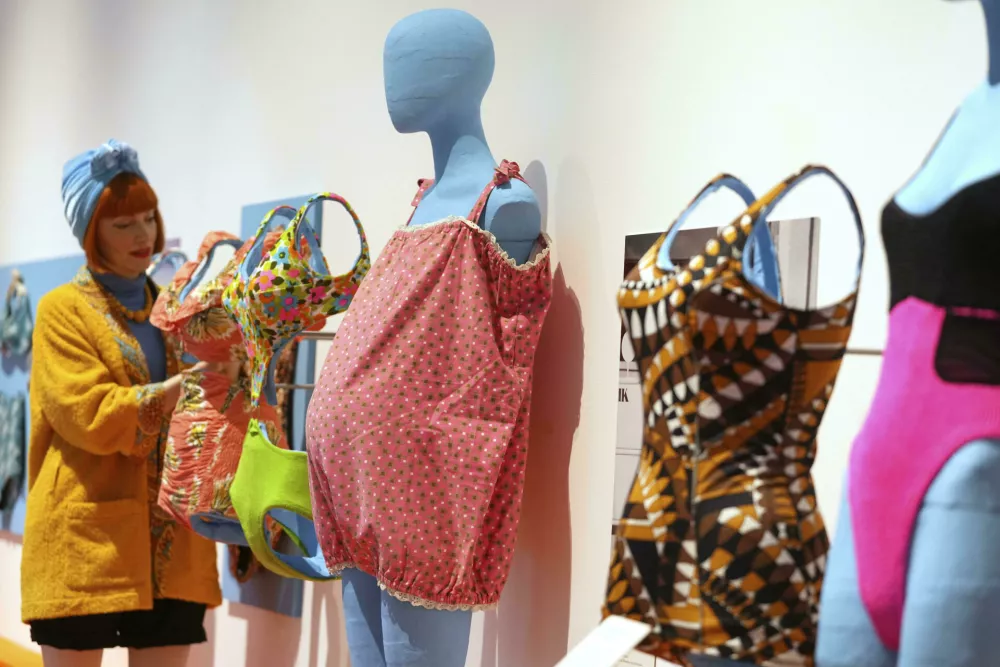 Guest curator Amber Butchart adjusts a swimsuit on display at 'Splash! A century of Swimming and Style' an exhibition of swimwear and swim related items, at The Design Museum in London, Monday, March 24, 2025. (AP Photo/Kirsty Wigglesworth)