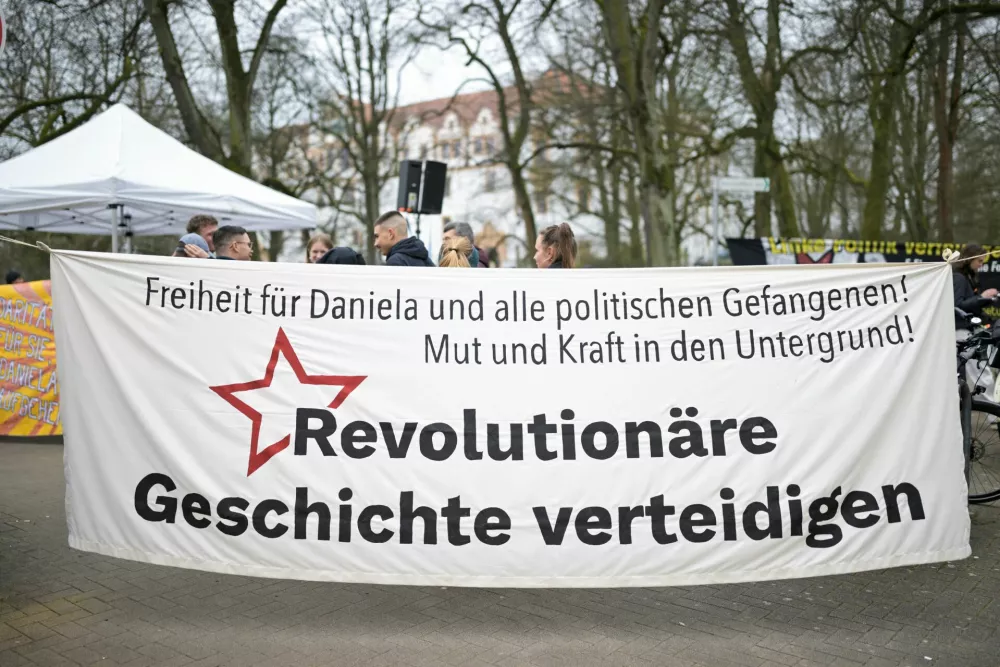 A banner that reads "Freedom for Daniela and all political prisoners, Courage and strength in the underground, Defending revolutionary history" is displayed as supporters of Daniela Klette, accused of being one of the last surviving members of the Red Army Faction group, who was arrested after decades on the run for armed robbery and attempted murder, attend a demonstration in front of a regional court on the day of her trial, in Celle, Germany, March 25, 2025. REUTERS/Fabian Bimmer