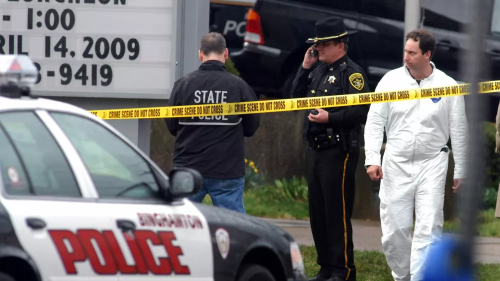 Police investigate a shooting scene outside the American Civic Center on Front Street in Binghampton, New York, April 3, 2009. A man armed with two handguns walked into an immigration services center and killed 13 people before apparently turning the gun on himself, police in Binghamton, New York, said on Friday.   REUTERS/Hans Pennink  (UNITED STATES CONFLICT SOCIETY DISASTER POLITICS)