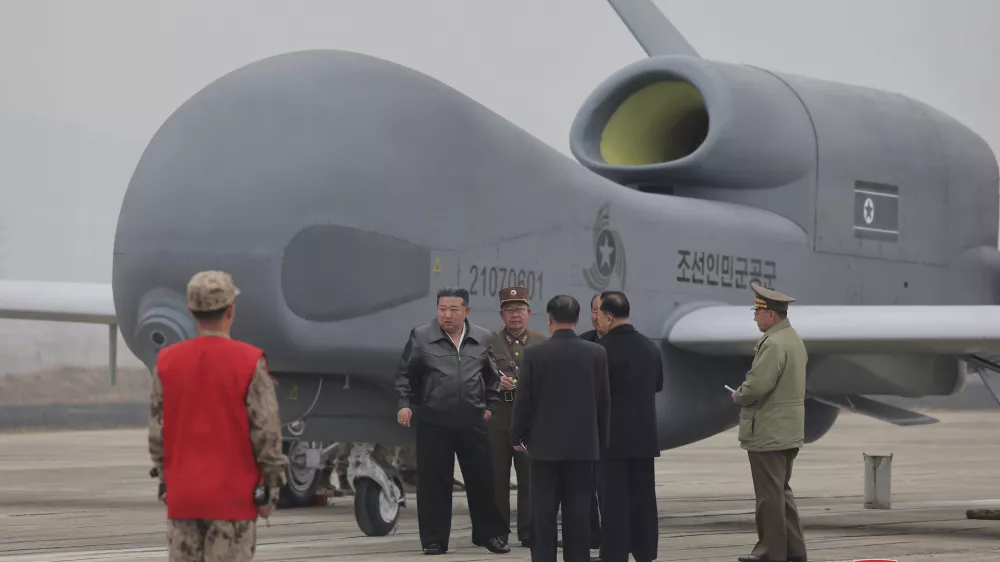 In this photo provided Thursday, March 27, 2025, by the North Korean government, its leader Kim Jong Un, center left in a black jacket, stands by what appeared to be a large reconnaissance drone at an undisclosed location in North Korea, earlier this week. Independent journalists were not given access to cover the event depicted in this image distributed by the North Korean government. The content of this image is as provided and cannot be independently verified. Korean language watermark on image as provided by source reads: "KCNA" which is the abbreviation for Korean Central News Agency. (Korean Central News Agency/Korea News Service via AP)