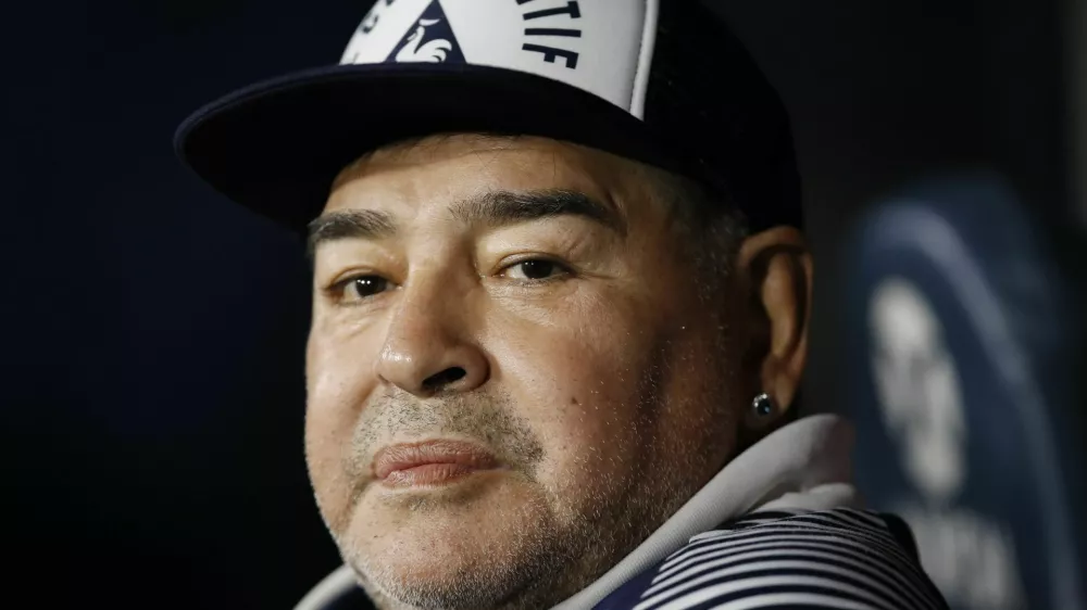 ﻿FILE - In this March 7, 2020 file photo, Diego Maradona, coach of Gimnasia y Esgrima, sits on the bench prior to Argentina's soccer league match against Boca Juniors at La Bombonera stadium in Buenos Aires, Argentina. Maradona turns 60 on Friday, Oct. 30, 2020. (AP Photo/Natacha Pisarenko, File)