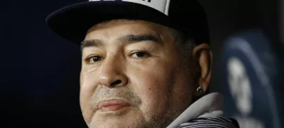 ﻿FILE - In this March 7, 2020 file photo, Diego Maradona, coach of Gimnasia y Esgrima, sits on the bench prior to Argentina's soccer league match against Boca Juniors at La Bombonera stadium in Buenos Aires, Argentina. Maradona turns 60 on Friday, Oct. 30, 2020. (AP Photo/Natacha Pisarenko, File)
