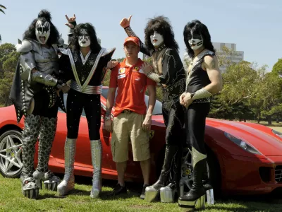 Defending world drivers champion Ferrari's Kimi Raikkonen of Finland, center, stands with U.S. rock group Kiss at the Albert Park circuit in Melbourne, Australia, Wednesday, March 12, 2008. The season's opening Formula One race will be held here on Sunday March 16. Members of the band are, from left, Gene Simmons, Tommy Thayer, Paul Stanley and Eric Singer. (AP Photo/Ercole Colombo)