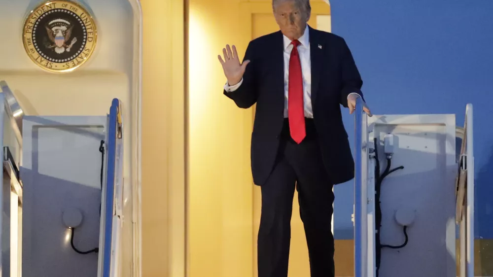 President Donald Trump waves as he walks down the stairs of Air Force One upon his arrival at Joint Base Andrews, Md., Sunday, March 30, 2025. (AP Photo/Luis M. Alvarez)