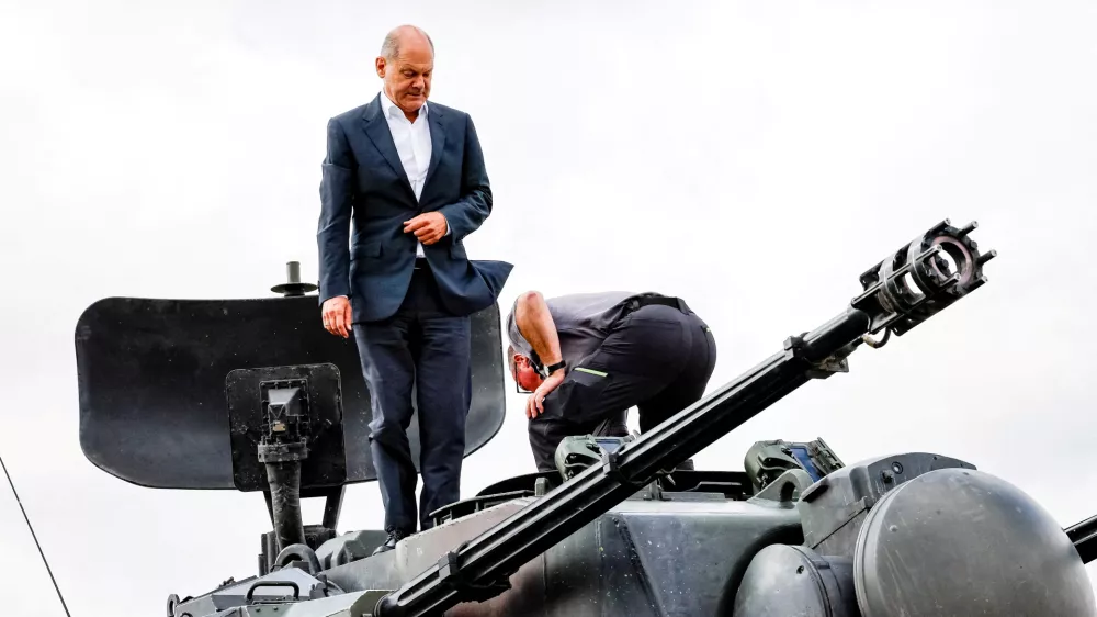 FILE PHOTO: German Chancellor Olaf Scholz climbs on a German self-propelled anti-aircraft gun Flakpanzer Gepard with head of training at arms manufacturer Krauss-Maffei Juergen Schoch, during a visit of the training program for Ukrainian soldiers on the Gepard anti-aircraft tank in Putlos near Oldenburg, Germany August 25, 2022. Axel Heimken/Pool via REUTERS/File Photo