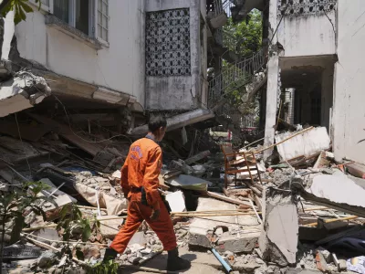A rescuer works through rubble of a collapsed building following Friday's earthquake in Naypyitaw, Myanmar, Tuesday, April 1, 2025. (AP Photo)