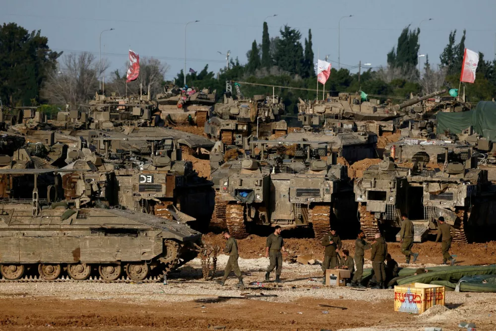FILE PHOTO: Israeli soldiers work by military vehicles, amid a ceasefire between Israel and Hamas, near the border with Gaza, in Israel, February 15, 2025. REUTERS/Amir Cohen/File Photo