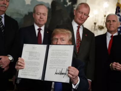 ﻿President Donald Trump displays signs a presidential memorandum imposing tariffs and investment restrictions on China in the Diplomatic Reception Room of the White House, Thursday, March 22, 2018, in Washington. (AP Photo/Evan Vucci)