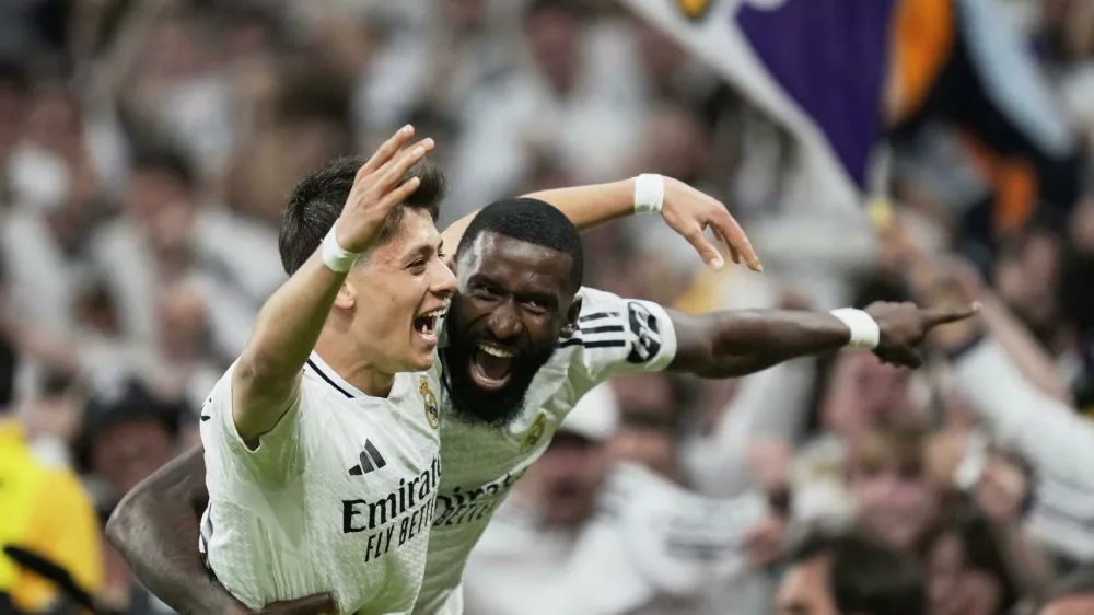 Real Madrid's Arda Guler, left, and Real Madrid's Antonio Rudiger celebrate after a fourth goal in extra time during the Spanish Copa del Rey semifinal second leg soccer match between Real Madrid and and Real Sociedad in Madrid, Spain Tuesday, April 1, 2025. (AP Photo/Bernat Armangue)