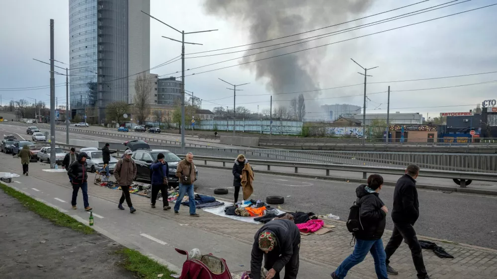 Vendors put their wares on display at a flea market as smoke rises from a nearby site of a Russian missile strike, amid Russia's attack on Ukraine, in Kyiv, Ukraine, April 6, 2025. REUTERS/Thomas Peter     TPX IMAGES OF THE DAY
