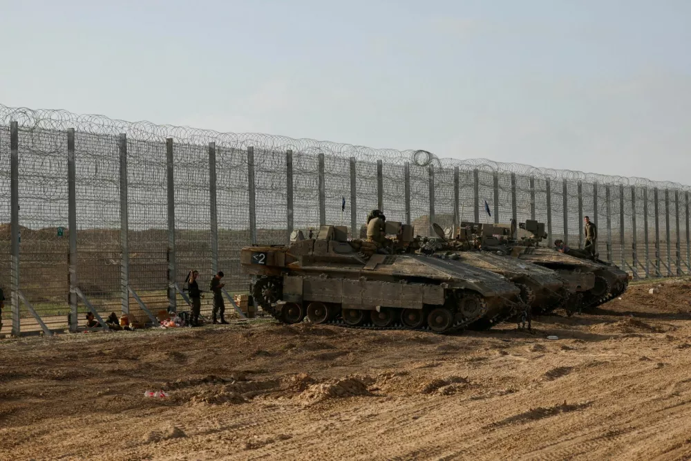 FILE PHOTO: Soldiers sit on top of APC's, at the Israel-Gaza border, in Israel, March 18, 2025. REUTERS/Amir Cohen/File Photo