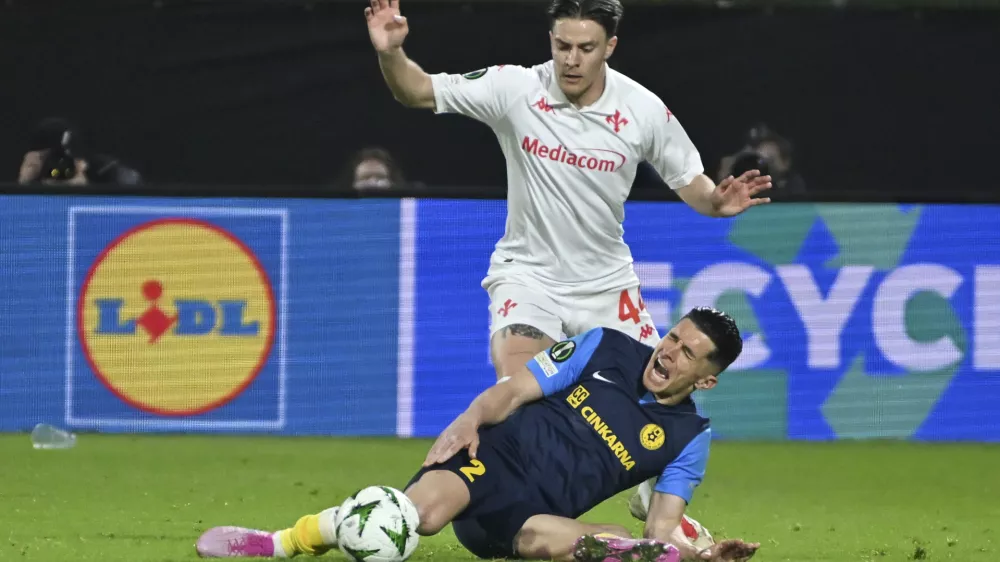 Celje's Juanjo Nieto is challenged by Fiorentina's Nicolo Fagioli, rear, during the Europa Conference League first-leg quarterfinal soccer match between Celje and Fiorentina in Celje, Slovenia, Thursday, April 10, 2025. (AP Photo/Igor Kupljenik)