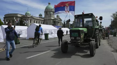 Tractors are parked in front of the Serbian parliament building ahead of a big counter-opposition protest rally planned to be staged over the weekend in downtown Belgrade, Serbia, Friday, April 11, 2025. (AP Photo/Darko Vojinovic)