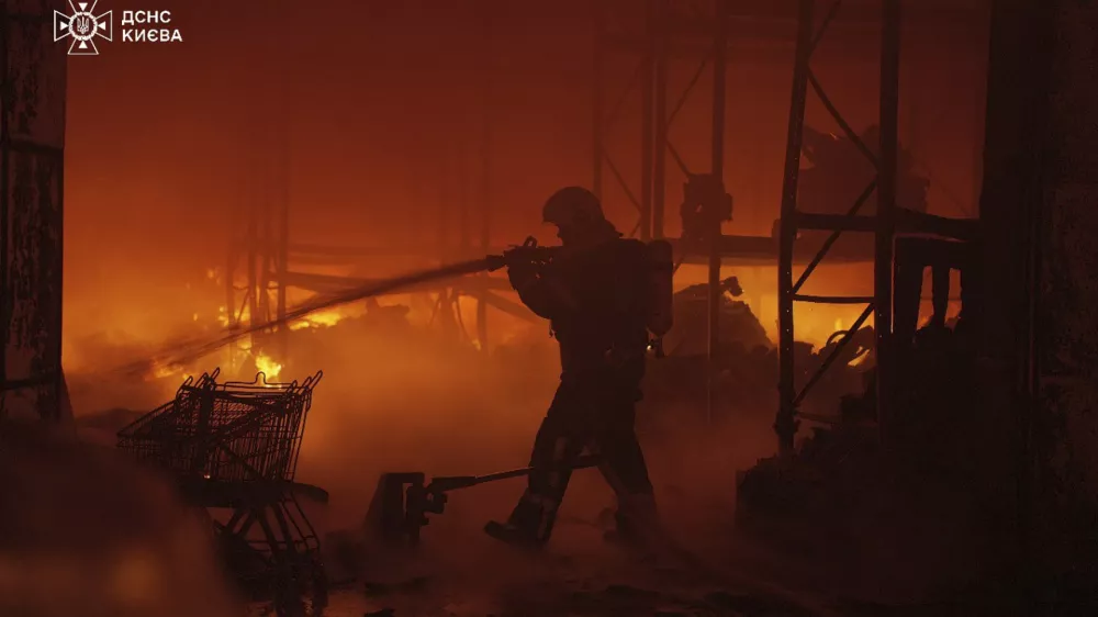 In this photo provided by the Ukrainian Emergency Service, emergency services personnel work to extinguish a fire following a Russian attack in Kyiv, Ukraine, Saturday, April 12, 2025. (Ukrainian Emergency Service via AP)