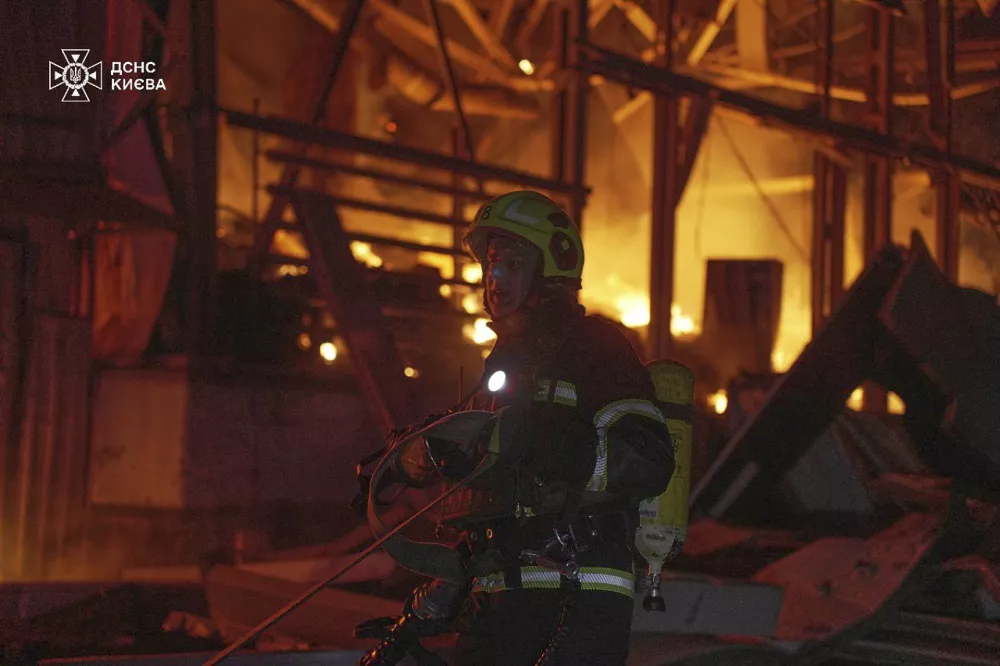 In this photo provided by the Ukrainian Emergency Service, emergency services personnel work to extinguish a fire following a Russian attack in Kyiv, Ukraine, Saturday, April 12, 2025. (Ukrainian Emergency Service via AP)