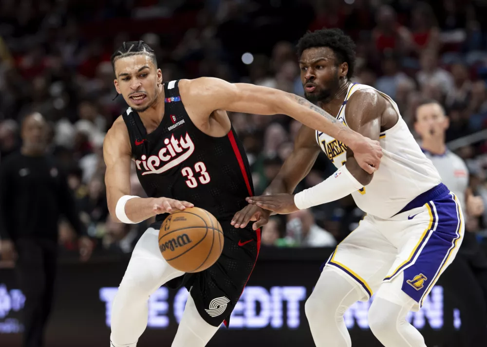 Portland Trail Blazers forward Toumani Camara, left, dribbles the ball against Los Angeles Lakers guard Bronny James, right, during the second half of an NBA basketball game Sunday, April 13, 2025, in Portland, Ore. (AP Photo/Howard Lao)