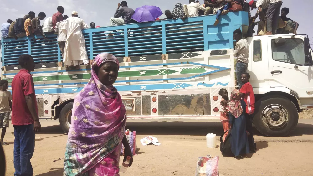 FILE - People board a truck as they leave Khartoum, Sudan, on June 19, 2023. (AP Photo, File)