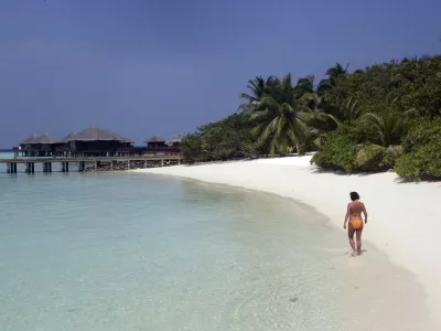 Renate Reinstaller, a tourist from Meran, Italy, walks a beach at the Baros Resort Island in the Maldives Saturday, Jan. 15, 2005. With French charter flights likely to resume soon and Italy lifting a warning against travel to the Indian Ocean archipelago, authorities are hoping that the balm of tourism would ease the impact of the Dec. 26 tsunami on Maldives. (AP Photo/Ed Wray)