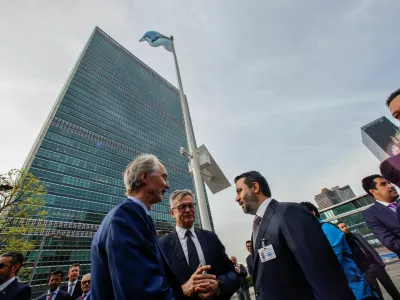 Syrian Foreign Minister Asaad Hassan al-Shibani speaks with UN Special Envoy for Syria, Geir Otto Pedersen, as they attend the raising ceremony of the new Syrian government flag, at United Nations Headquarters in New York, U.S., April 25, 2025. REUTERS/Eduardo Munoz