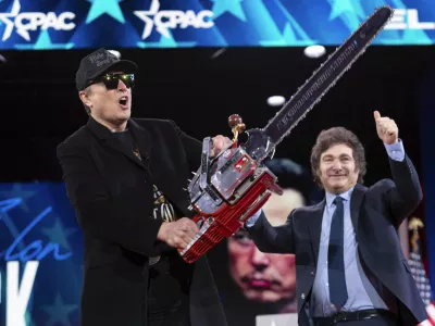 Elon Musk holds up a chainsaw he received from Argentina's President Javier Milei, right, as they arrive to speak at the Conservative Political Action Conference, CPAC, at the Gaylord National Resort & Convention Center, Thursday, Feb. 20, 2025, in Oxon Hill, Md. (AP Photo/Jose Luis Magana)