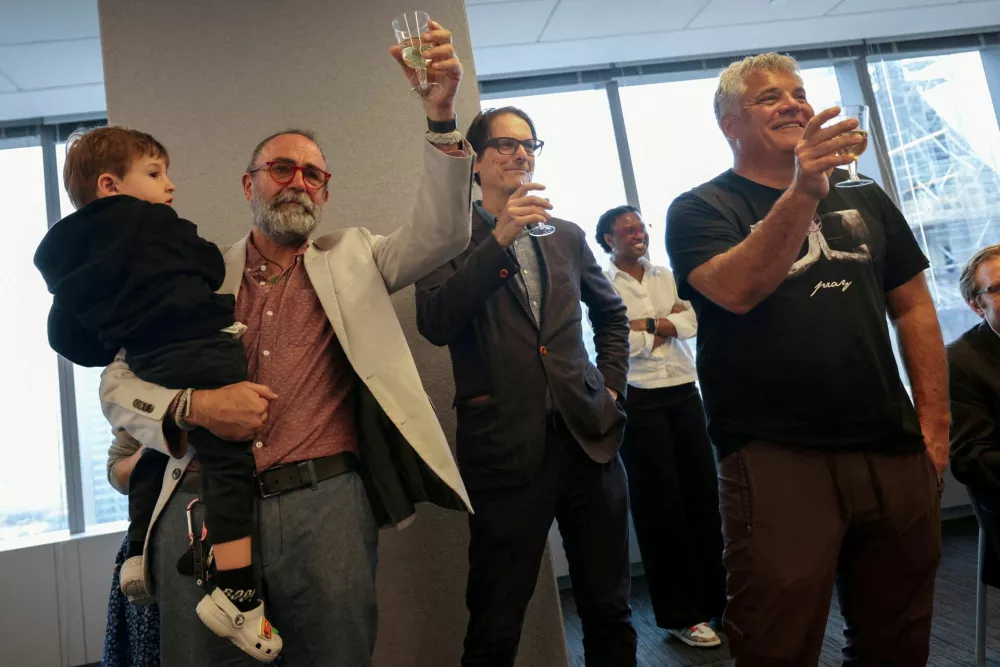 Reuters journalist Maurice Tamman holding his grandson Levi, Global Enterprise Editor Mike Williams and Senior Photographer Shannon Stapleton toast together after the Reuters staff was awarded a Pulitzer Prize in the Investigative Reporting category for 'Fentanyl Express', a series of stories that penetrated the international trade in the chemicals used to make fentanyl, at the Reuters Newsroom in New York City, U.S., May 5, 2025. REUTERS/Mike Segar