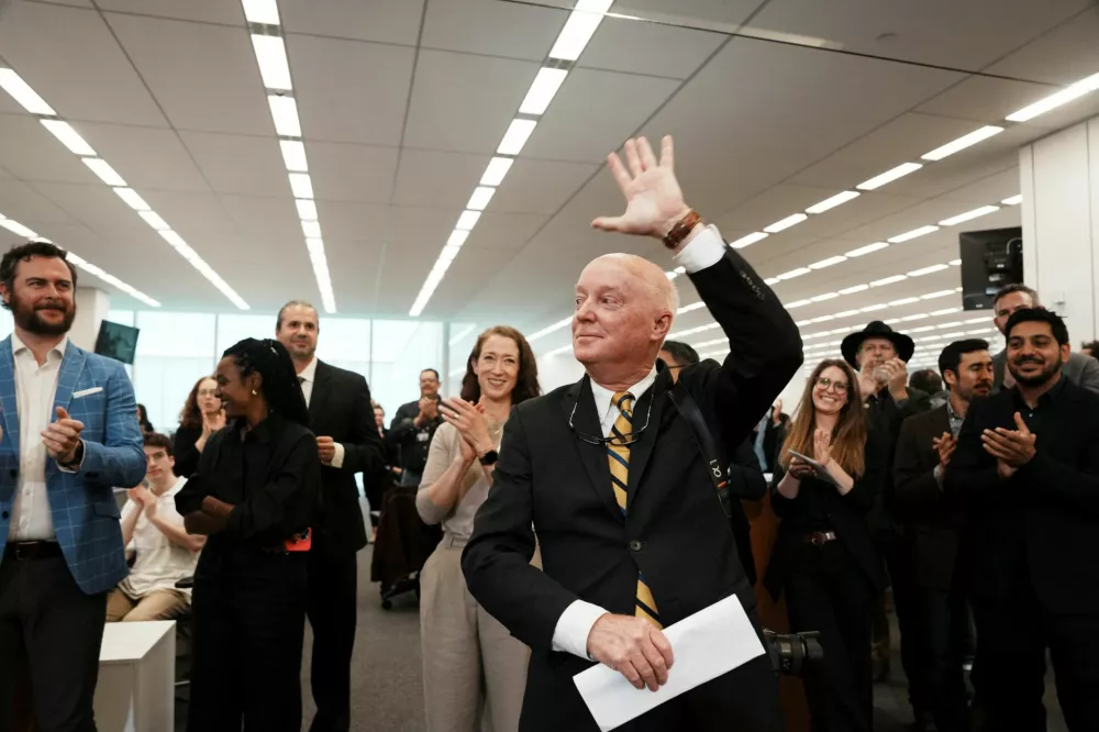 Doug Mills acknowledges applause as Meaghan Mulcahy, director of photography, looks on after it was announced that he won the 2025 Pulitzer Prize for breaking news photography for his coverage of the attempted assassination of Donald Trump in Butler, Pennsylvania, during a gathering in the newsroom of The New York Times in New York City, U.S. May 5, 2025. Hiroko Masuike/The New York Times/Handout via REUTERS  NEW YORK CITY OUT. NO RESALES. NO ARCHIVES. THIS IMAGE HAS BEEN SUPPLIED BY A THIRD PARTY