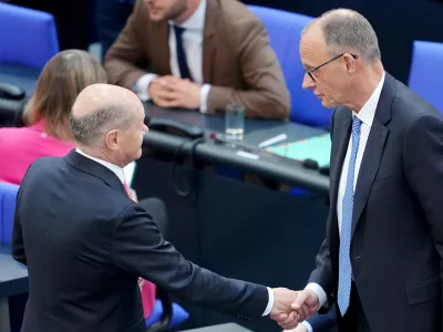 06 May 2025, Berlin: Acting Federal Chancellor Olaf Scholz shakes hands with Chancellor candidate Friedrich Merz during the second round of Chancellor election. Merz failed the first round of voting in the Bundestag. Photo: Kay Nietfeld/dpa