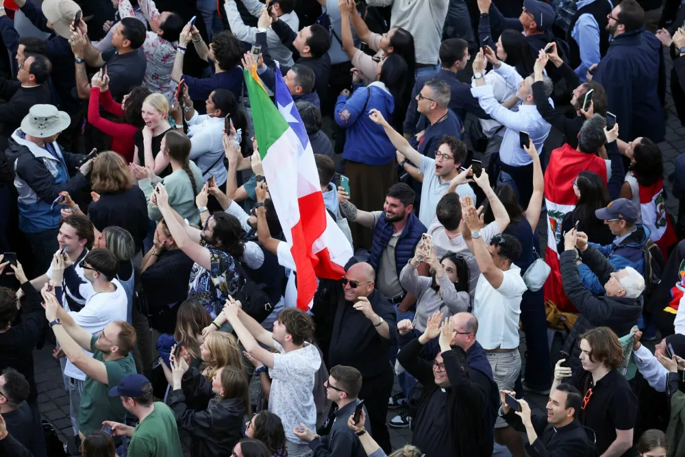 Faithful react to white smoke rising from the chimney on the Sistine Chapel indicating that a new pope has been elected, at the Vatican, May 8, 2025. REUTERS/Claudia Greco