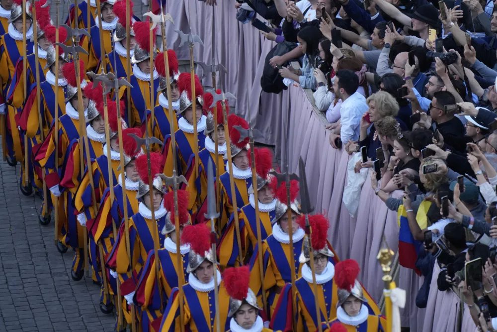 Vatican Swiss guards march in St Peter's Square after white smoke billowed from the chimney of the Sistine Chapel where 133 cardinals are gathering on the second day of the conclave to elect a successor to late Pope Francis, at the Vatican, Thursday, May 8, 2025. (AP Photo/Luca Bruno)