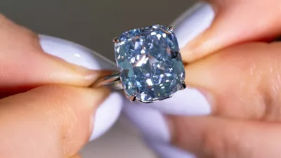 A Sotheby's staff holds "The Mediterranean Blue", a fancy vivid blue diamond weighing 10.03 carats estimated to reach 20 million Swiss francs during an auction preview in Geneva, Switzerland, May 8, 2025. REUTERS/Denis Balibous