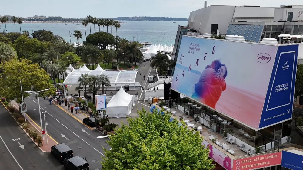 A drone view shows a giant canvas of one of the official double poster featuring a joint tribute to the two actors Anouk Aimee and Jean-Louis Trintignant in the film "A Man and a Woman" (Un homme et une femme) on the Festival Palace, ahead of the opening ceremony of the 78th Cannes Film Festival in Cannes, France, May 11, 2025. REUTERS/Sarah Meyssonnier