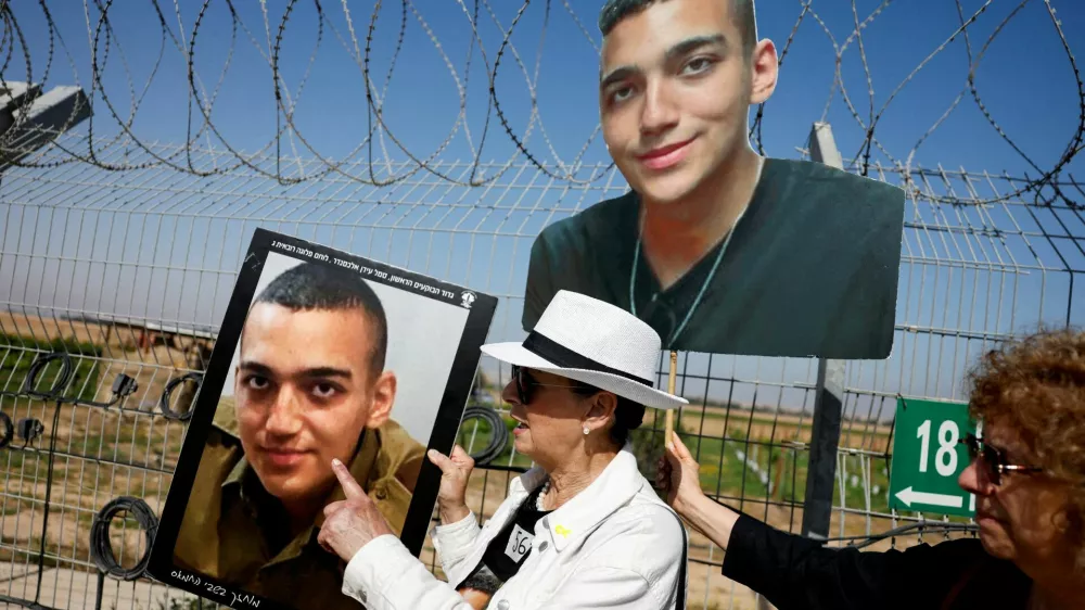 FILE PHOTO: Varda Ben Baruch, grandmother of hostage Edan Alexander, points at the portrait of Edan, as family members and supporters of hostages who were kidnapped during the deadly October 7 attack, stand near the kibbutz defence on the day they use giant loudspeakers to call their captive loved ones over the border between Israel and Gaza, at Kibbutz Nir Oz, in southern Israel, April 20, 2025. REUTERS/Amir Cohen/File Photo