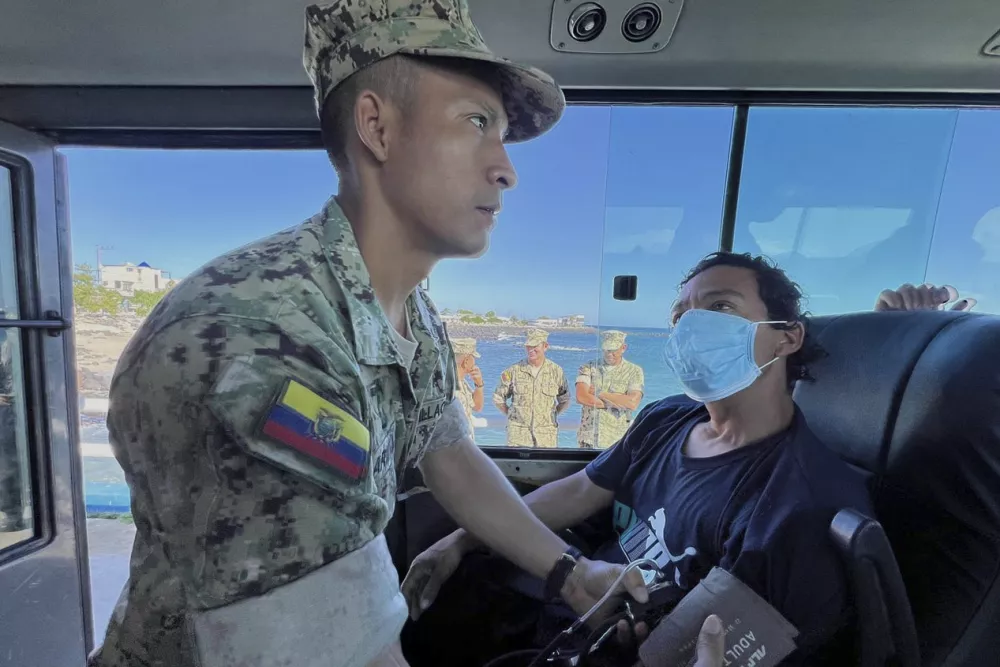 In this government handout photo a soldier checks the vitals of one of five shipwrecked fishermen, who were rescued by an Ecuadorian tuna fishing boat after being adrift for more than 50 days, at the San Cristobal Naval Base, Galapagos Islands, Ecuador, Saturday, May 10, 2025. (Ecuadorean Navy via AP)