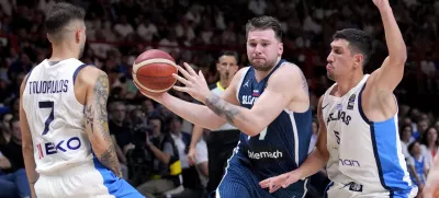 Slovenia's Luka Doncic drives between Greece's Giannoulis Larentzakis, right, and Vasileios Toliopoulos during an Acropolis tournament basketball match, at the Peace and Friendship indoor stadium at Athens' port city of Piraeus, Greece, Saturday, July 6, 2024. (AP Photo/Petros Giannakouris)