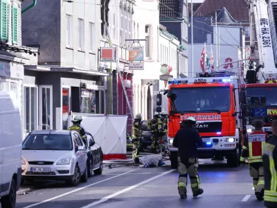 25 March 2024, North Rhine-Westphalia, Solingen: Firefighters and emergency vehicles stand in front of a house where a fire broke out killing three people, including a child. Photo: David Young/dpa