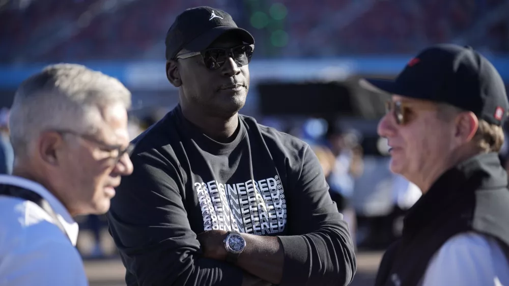 FILE - Michael Jordan, center, and Curtis Polk, left, co-owners of 23XI Racing, watch during qualifying beside 23XI Racing President Steve Lauletta, right, for a NASCAR Cup Series Championship auto race, Nov. 9, 2024, in Avondale, Ariz. (AP Photo/John Locher, file)